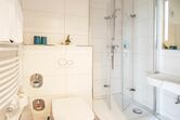 Badezimmer mit ebenerdiger Dusche und Handtuchwärmer