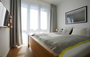 Schlafzimmer mit Doppelbett und TV
