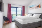 1.Schlafzimmer mit Doppelboxspringbett und TV
